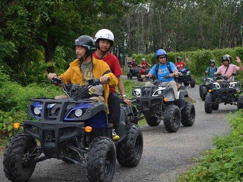 Tourists riding ATV through lush green forest at ATV Adventure Ride Langkawi